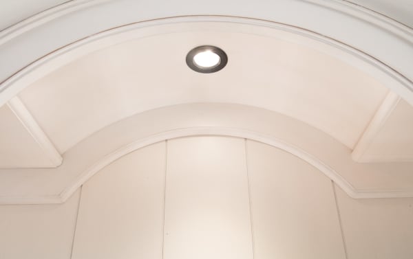 Recessed touch light inside the arch of the Scarlett 2 Piece White & Oak China Cabinet from the Scarlett Dining collection, featuring cottage style MDF, poplar solids, and oak veneers with a distressed antique white finish.