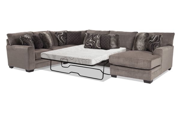 Luxe Gray 150'' 4-piece right arm transitional sleeper chaise sectional in soft gray polyester fabric with patterned and faux fur accent pillows, featuring a queen cooling Bob-O-Pedic gel memory foam mattress for comfort and space-saving functionality.