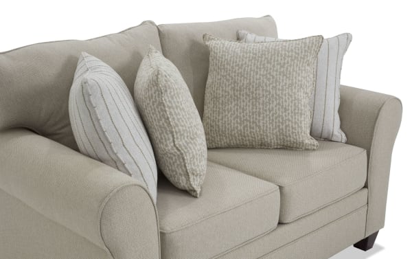 Beige Laurel 65'' transitional loveseat with rolled arms, plush Bob-O-Pedic memory foam cushions, and four beige patterned accent pillows, upholstered in durable polyester fabric.