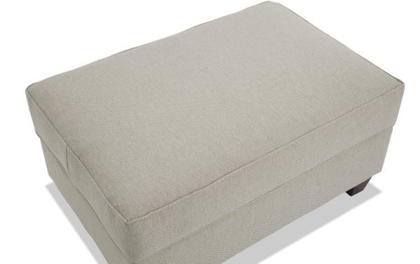Beige Laurel Storage Ottoman with plush Bob-O-Pedic memory foam seating, transitional style, polyester fabric upholstery, and durable polypropylene frame.