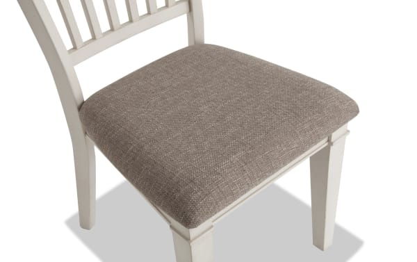 Beige fabric-upholstered seat with memory foam on a Montana White & Beige Slat Back Dining Chair, featuring rustic white rubberwood frame and traditional slat back design.