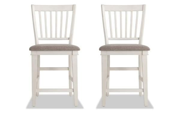 Set of 2 Montana White & Beige Slat Back Counter Height Stools with rustic white rubberwood frame, beige polyester fabric seats, and traditional slat back design.