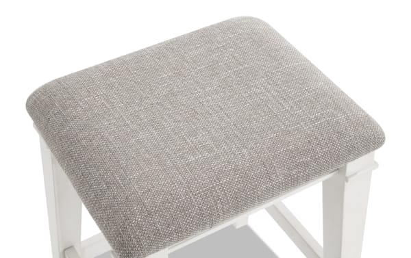 Beige fabric upholstered counter height stool with cushioned seat, rustic style, rubberwood frame, and sturdy square legs from Montana Dining collection.