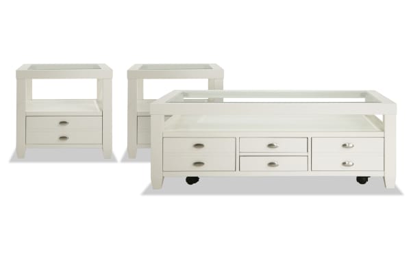 Prestige White Storage Coffee & 2 End Table Set from Prestige Occasional, transitional style with white solid acacia, MDF, beveled tempered glass tops, display shelves, multiple storage drawers, removable serving trays, and casters on the coffee table for easy mobility.