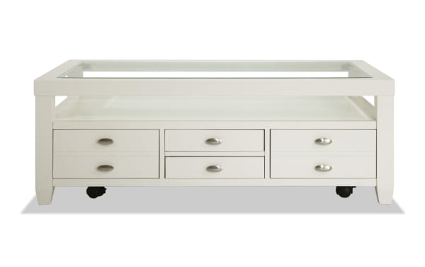 Transitional Prestige White Storage Coffee Table with glass top, beveled edges, solid acacia & MDF, casters, and multiple storage drawers from Prestige Occasional collection.