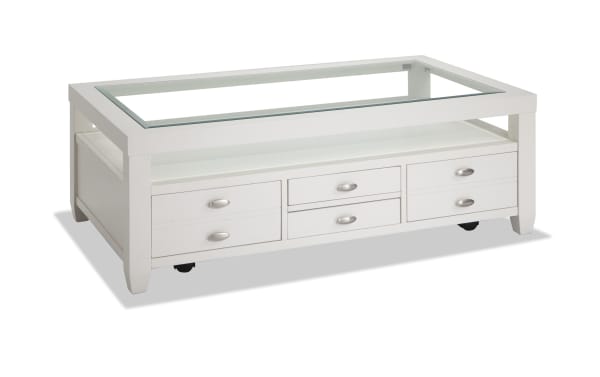 White Prestige Occasional transitional coffee table with tempered glass top, beveled edges, solid acacia and MDF frame, casters, and multiple storage drawers.
