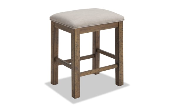Beige upholstered counter height stool from Sonoma Dining collection, featuring solid acacia wood frame, plush polyester fabric seat, and transitional rustic style.
