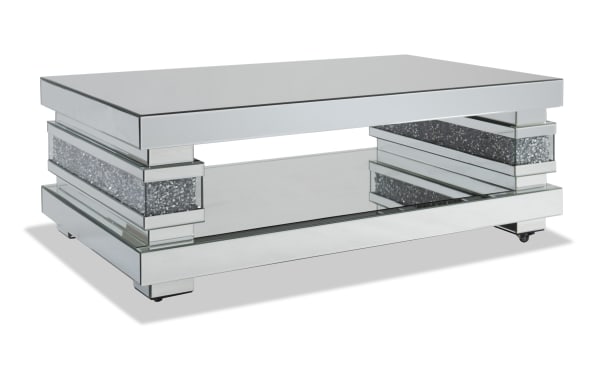 Glamour Silver Mirrored Coffee Table from Glamour Entertainment & Occasional collection, featuring a glam style with MDF and tempered glass, beveled edges, faux crushed crystal inlay, open lower shelf, and a reflective silver finish for a luxurious living room accent.