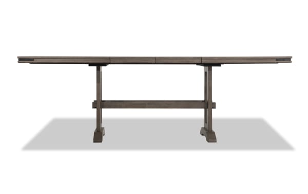 Hudson Gray Extendable Counter Height Trestle Dining Table in transitional style, wood and mango veneer with metal corner accents and two 18-inch leaves.