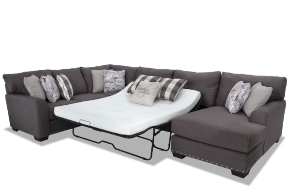 Cottage Chic 4-piece right arm facing gray polyester fabric sleeper sectional with queen gel memory foam mattress, nailhead trim, and 10+ accent pillows.