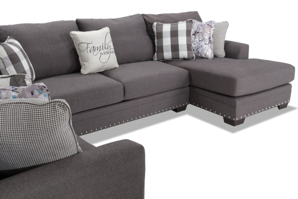 Cottage Chic Gray 4-piece right arm facing sleeper chaise sectional with gray polyester fabric, nailhead trim, and 10+ accent pillows.