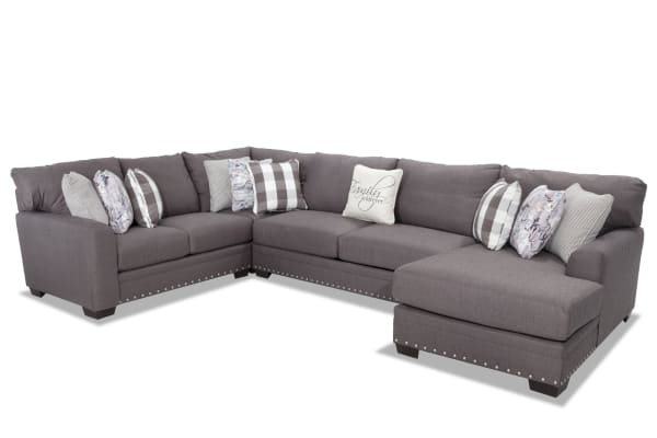Cottage Chic gray 4-piece right arm facing sleeper chaise sectional with polyester fabric, nailhead trim, and 10 accent pillows in traditional style.