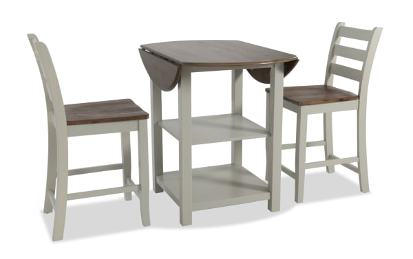 Sawyer 3 Piece Gray & Natural Drop Leaf Storage Counter Height Dining Set with MDF, transitional style, featuring a two-tone drop leaf table with shelves and two matching stools.
