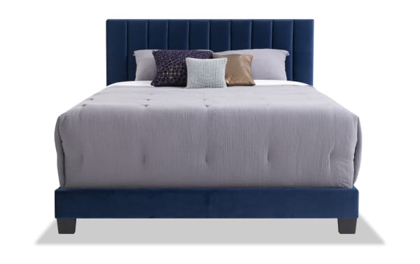 Aster Full Blue Upholstered Panel Bed with vertical tufting, thick side rails, and soft blue polyester fabric. Transitional style with sturdy slats and center leg support.