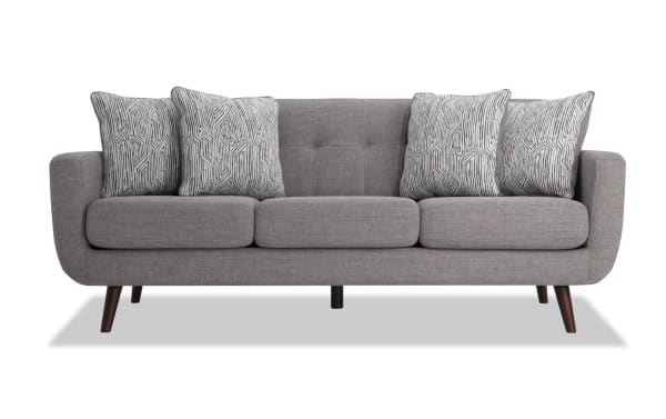 Mid-century modern Bettie Gray 86" sofa in gray polyester fabric with tufted back, track arms, wooden legs, and four patterned accent pillows.