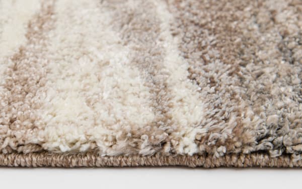 Close-up of Valley 8' x 10' Beige Abstract Rug showing plush heat set polypropylene fibers in beige tones with organic shapes, contemporary style, and fabric polyester texture.