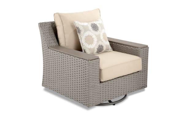 Beige Cottage Chic Outdoor swivel chair with all-weather wicker, powder-coated aluminum frame, and plush polyester cushions with floral accent pillow.