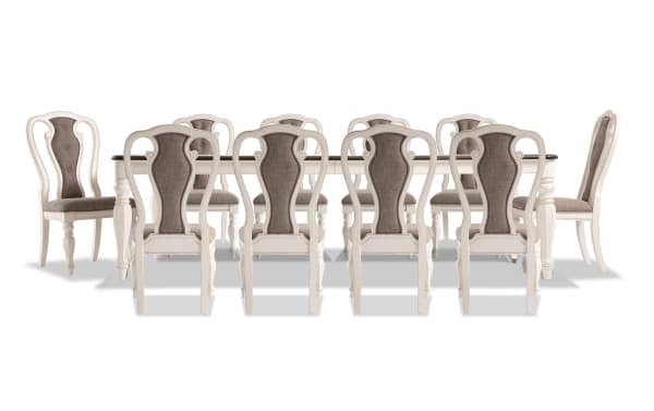 Scarlett 11 Piece Beige Upholstered Extendable Dining Set with wire brushed oak top, carved legs, antique white finish, and cushioned fabric chairs.