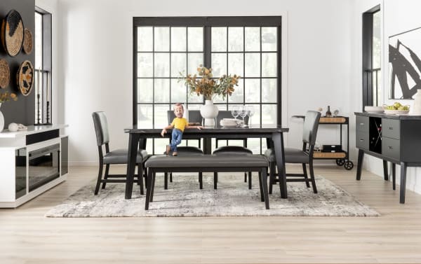 Transitional Elm Dining Bench in light gray polyester fabric upholstery with MDF frame, sturdy legs, and foam-filled cushioning, paired with black dining table and chairs.
