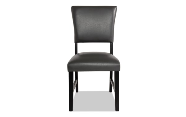 Transitional Elm Dining Chair in gray faux leather upholstery with padded panel back, foam-filled seat, and sturdy black MDF legs.