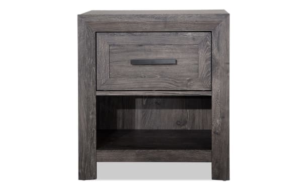 Calvin Gray Nightstand with Drawer from Calvin Bedroom collection, featuring engineered wood grain, contemporary style, gray finish, felt-lined drawer, and open lower shelf for versatile storage.