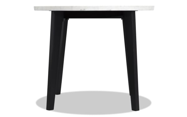 Round counter height dining table from the Elm Dining collection with a white marble top and black wooden legs in a transitional style.