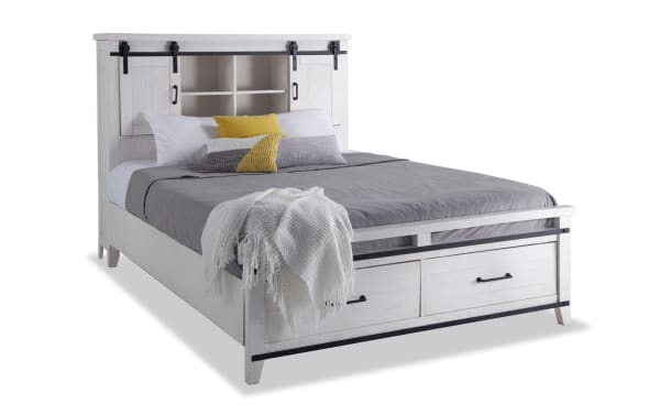 Montana 4 Piece Queen White Bookcase Storage Bedroom Set with rustic pine solids, MDF, and pine veneer. Features a white bookcase bed with built-in storage compartments, USB ports, power outlets, and two footboard drawers. Rustic style with black metal hardware and a gray bedding set.