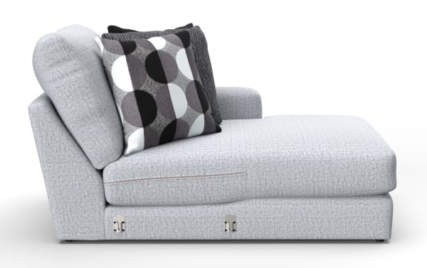 Light gray fabric chaise lounge with textured upholstery, featuring two decorative pillows—one with black, white, and gray geometric circles and another solid dark gray pillow.