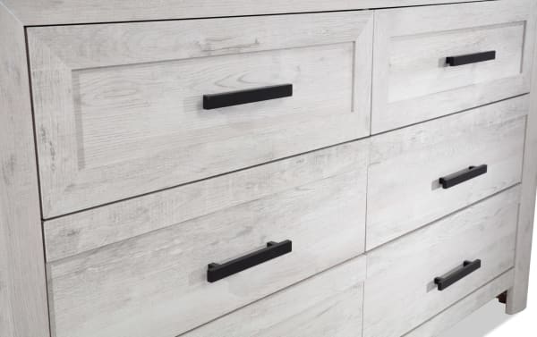 Calvin White 6 Drawer Dresser from Calvin Bedroom collection, featuring engineered wood grain, contemporary style, black handles, and spacious whitewashed drawers.