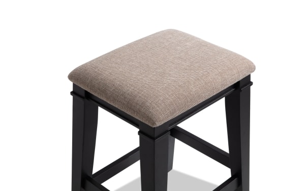 Montana Black & Beige Backless Upholstered Counter Height Stool with beige polyester fabric seat, rustic MDF wooden frame, and memory foam cushion.