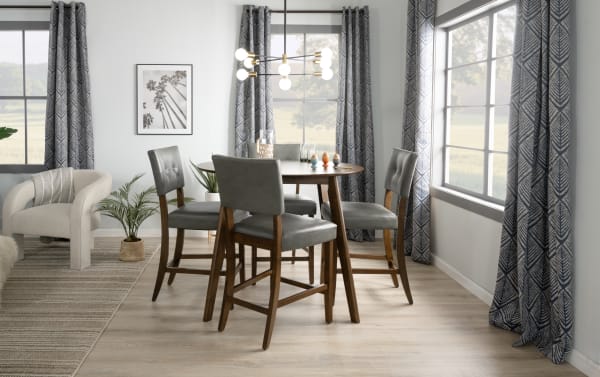Mid-century modern Bettie Walnut & Charcoal dining chairs with charcoal faux leather upholstery, curved legs, and memory foam seats around a walnut dining table.