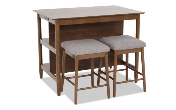 Wooden kitchen island with two cushioned gray fabric stools, featuring open shelving and a warm brown finish, ideal for compact dining or workspace.