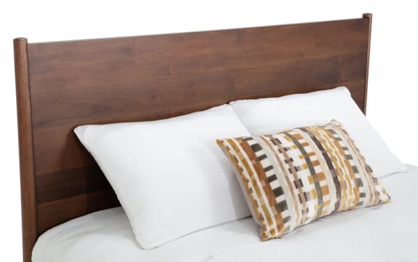Bettie Full Brown Platform Bed with mid-century modern style, walnut veneer legs, warm brown MDF wood headboard, and white bedding with decorative pillow.