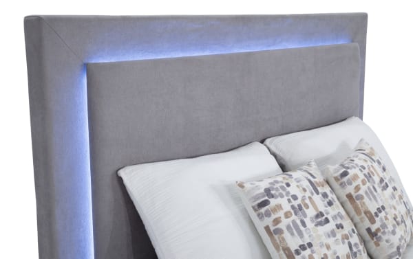 Performa Queen Gray Upholstered Panel Bed with plush polyester fabric, contemporary design, and soft LED backlighting on headboard.