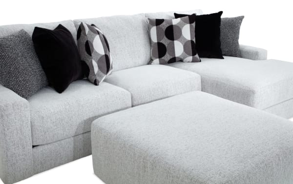 Mason White 123" 2-piece right arm facing chaise sectional with oversized ottoman, white polyester fabric, transitional style, includes six black and patterned accent pillows.