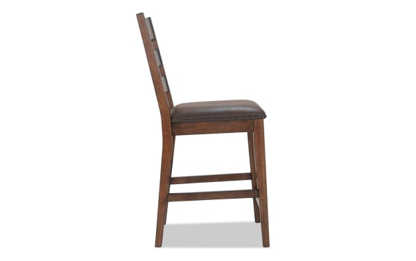 Canyon Brown Faux Leather Ladder Back Counter Height Stool with rustic brown MDF frame, faux leather seat, and memory foam upholstery from Canyon Dining collection.