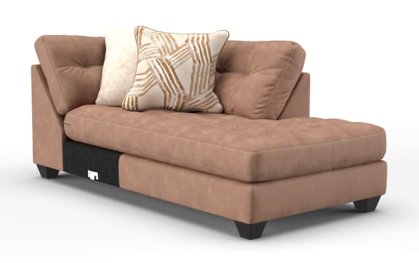 Modern tan leather chaise lounge with tufted seat, angled backrest, and two decorative throw pillows in beige and geometric patterns.