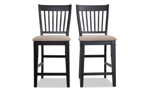 Set of 2 Montana Dining rustic counter height stools with black slat back, beige polyester fabric seats, and memory foam padding, made of MDF, oak veneers, plywood, and rubberwood solids.