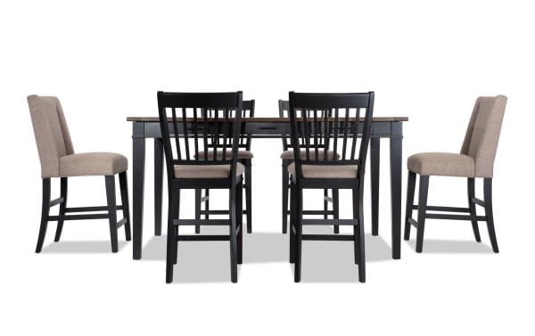 Montana 7 Piece Black & Beige Upholstered Counter Height Dining Set with rustic rubberwood, oak veneer table, six storage drawers, and beige polyester fabric chairs.