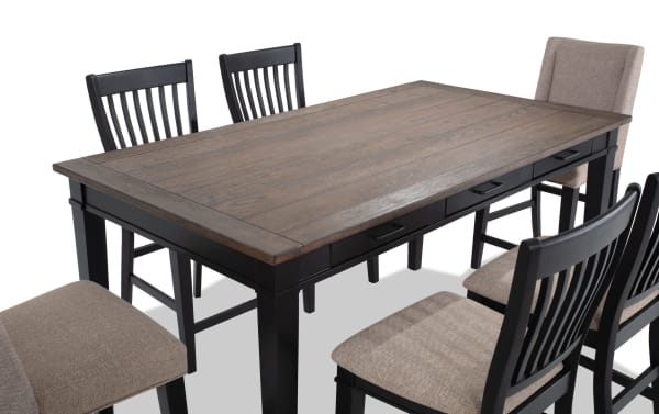 Montana 7 Piece Black & Beige Upholstered Counter Height Dining Set with rustic rubberwood and oak veneer top, beige polyester fabric chairs, and six storage drawers.