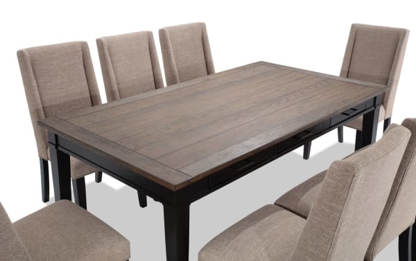 Montana 9 Piece Black & Beige Upholstered Dining Set with rustic rubberwood and oak veneer table, six storage drawers, and beige polyester fabric chairs with memory foam.
