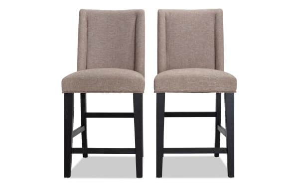 Set of 2 Montana Dining rustic counter height stools with beige polyester fabric upholstery, solid back, memory foam seat, and black wood legs.