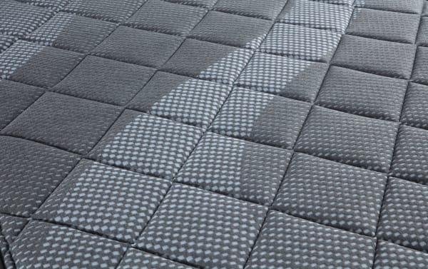 Synergy 10'' Queen Firm Boxed Mattress with quilted gray fabric cover, textured square pattern, and breathable foam layers for comfort and support.