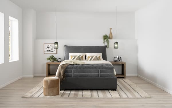 Queen-sized Treasure 11.5'' Dual Mattress in dark gray with quilted knit cover, gel-infused foam, memory foam, and wrapped coil system, styled in a modern bedroom.