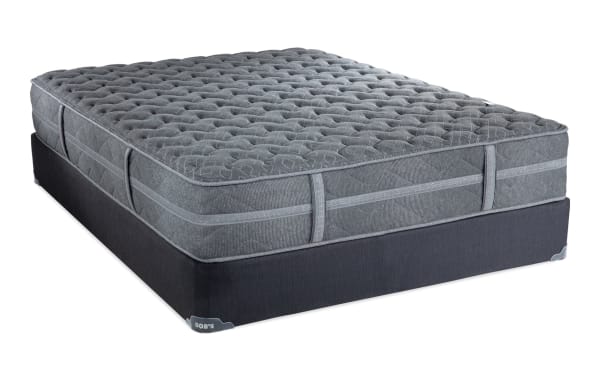 Treasure 11.5'' Queen Cushion Firm Standard Mattress Set by Bob’s, featuring a gray quilted knit cover, gel-infused foam layers, and firm edge support.