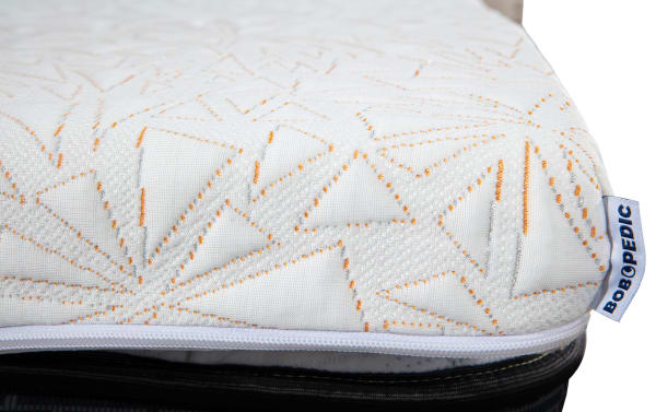 Copper Sport Twin XL Mattress Topper with white fabric, orange and gray geometric stitching, and BOB O P E D I C brand tag, featuring a zippered cover.
