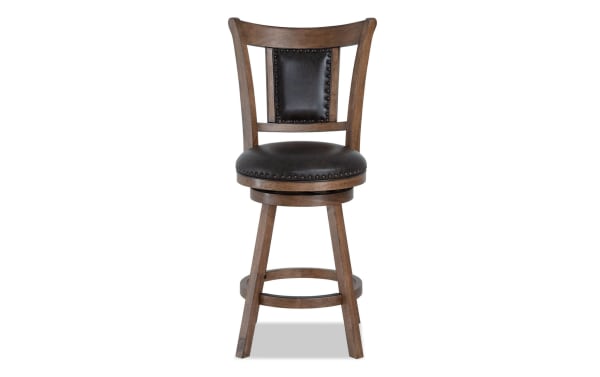 Owen Brown Faux Leather Upholstered Adjustable Height Swivel Stool with nailhead trim, memory foam seat, and transitional wood frame.
