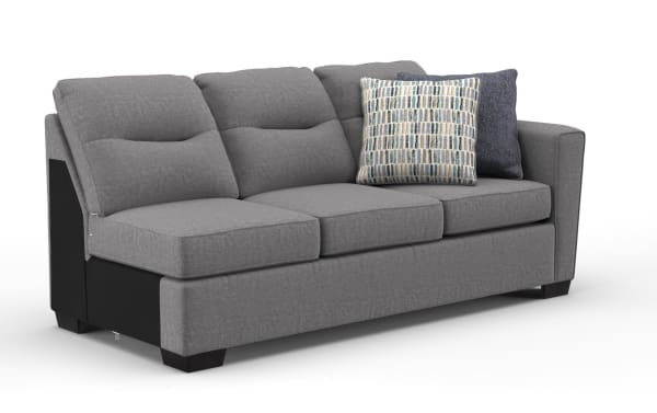 Modern gray fabric sofa with three cushioned seats and backrests, featuring two decorative patterned throw pillows, ideal for living room seating.