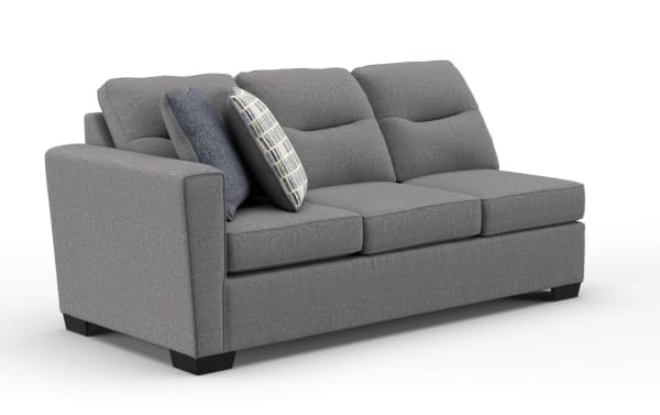 Gray fabric three-seater sofa with plush cushions, two decorative pillows, and dark wooden legs, suitable for modern living rooms.