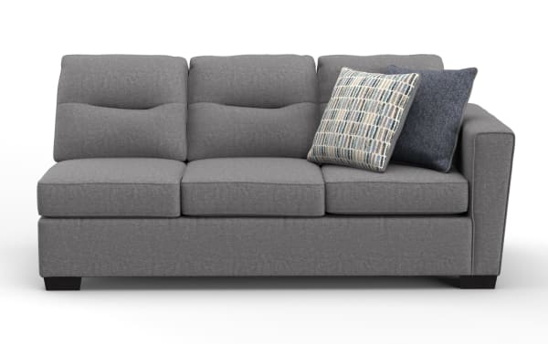 Modern gray fabric three-seater sofa with tufted back cushions, two decorative pillows, and a right armrest, ideal for living room seating.